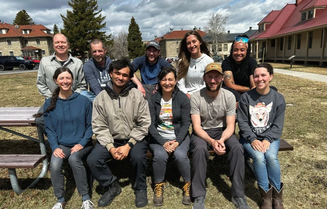 Members of the Yellowstone Wolf Project team seated together outdoors